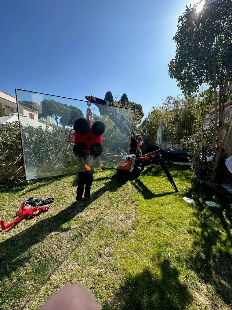 Grande baie vitrée suspendue au palonnier au-dessus d'un jardin