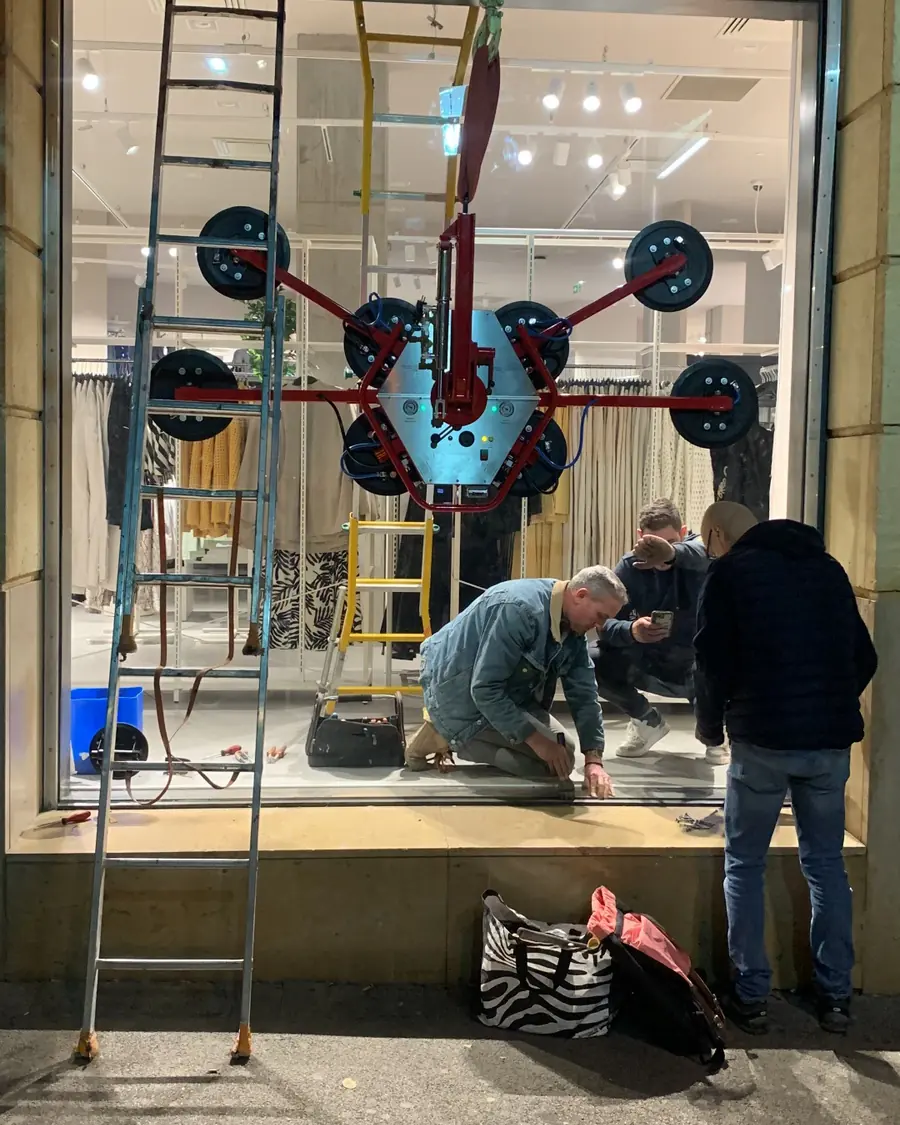 Mini-grue soulevant un grand vitrage devant un mas provençal